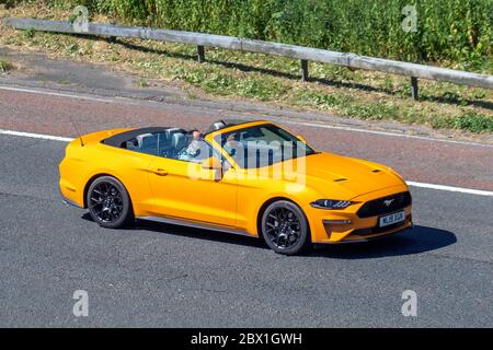 2019 Ford Mustang Ecoboost Auto (orange); Fahrzeugverkehr fahrende Fahrzeuge, Fahrzeuge, die Fahrzeuge auf britischen Straßen fahren, Motoren, Fahren auf der Autobahn M6, Cabriolet, Cabriolet, Faltverdeck, offenes Dach, roadster, Cabriolets, Absetztafeln Stockfoto