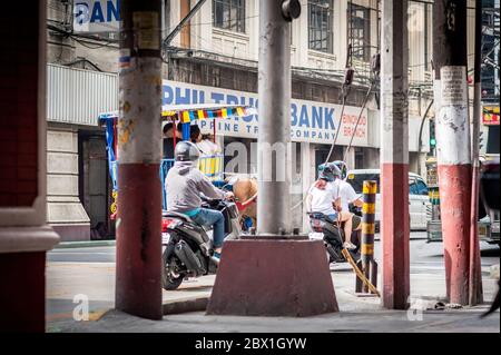 Alle Arten von Verkehr und Fußgänger passieren unter dem Filipino Chinese Friendship Arch im Binondo District, China Town, Manila, den Philippinen. Stockfoto