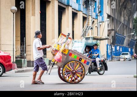 Ein Straßenhändler geht unter dem Filipino Chinese Friendship Arch im Binondo District, China Town, Manila, Philippinen. Stockfoto