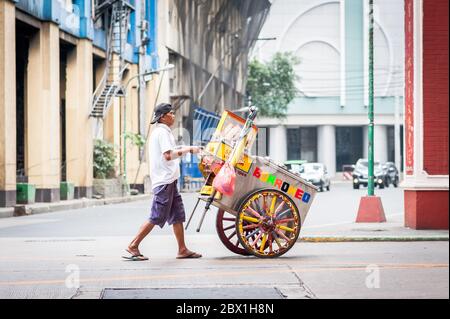 Ein Straßenhändler geht unter dem Filipino Chinese Friendship Arch im Binondo District, China Town, Manila, Philippinen. Stockfoto