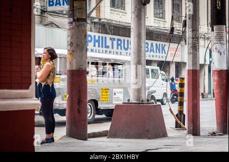 Verkehr und Fußgänger passieren den Filipino Chinese Friendship Arch im Binondo District, China Town, Manila, Philippinen. Stockfoto