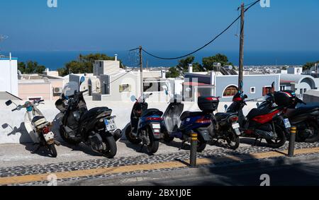 Fira, Griechenland - Juli 19 2019: Eine Linie Mopeds parkt auf 25is Martiou Stockfoto