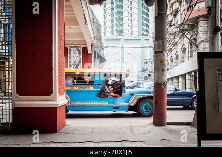 Verkehr und Fußgänger passieren den Filipino Chinese Friendship Arch im Binondo District, China Town, Manila, Philippinen. Stockfoto