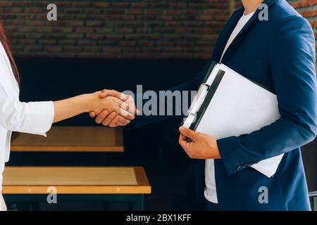 Geschäftspartner schütteln sich nach Vertragsunterzeichnung die Hände. Stockfoto
