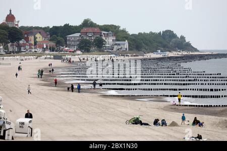 04. Juni 2020, Mecklenburg-Vorpommern, Kühlungsborn: Einige Leute gehen über den Strand. Dicke Wolken und sinkende Temperaturen lassen jedoch für die meisten Urlauber kein Strandwetter zu. Foto: Bernd Wüstneck/dpa-Zentralbild/dpa Stockfoto