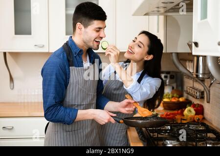 Schönes junges Paar bereitet leckeres Abendessen zusammen Stockfoto