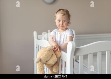 Fröhliches kleines Mädchen spielt mit einem Teddybären in einer guten Stimmung. Stockfoto