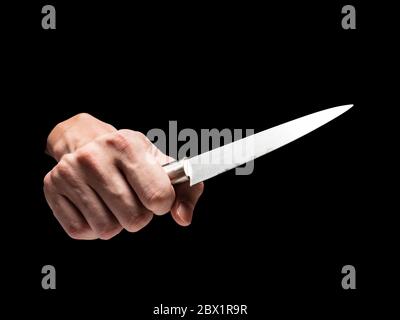Männliche Hand hält Messer auf schwarzem Hintergrund. Stockfoto