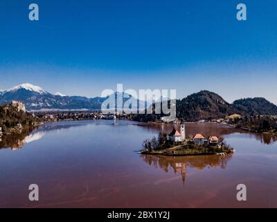 Berühmte See rote Farbe und Insel Bled (Blejsko jezero) in Slowenien. Schöner Bergsee mit Wallfahrtskirche Mariä Himmelfahrt Stockfoto