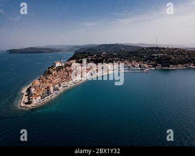 Luftaufnahme auf Piran Stadt mit altem Leuchtturm, alten Gebäuden mit roten Dächern, den Hafen von Piran mit Booten und Adria im Südwesten Sloweniens Stockfoto