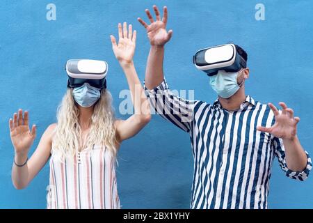 Junges Paar trägt Gesicht chirurgische Maske Spaß mit Virtual Reality Brille während Ausbruch Stockfoto