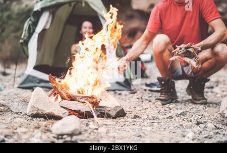 Happy Pärchen Feuer machen beim Campen in wilden Wald - Junge Leute haben Spaß beim Reisen und Campen next Lagerfeuer - Reise Urlaub Lifestyle-Konzept Stockfoto