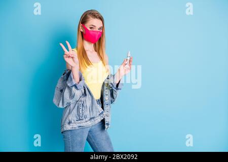 Profilfoto der schönen Dame verwenden Organizer antiseptische Spray desinfizieren Arme in Menge soziale Orte zeigen V-Zeichen tragen Gesichtsmaske Denim Blazer gelb Stockfoto