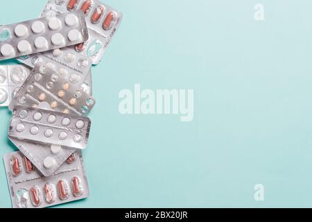Kapseln, Pillen in Blisterpackungen auf blauem Hintergrund. Das Konzept der Behandlung von Krankheiten, Gesundheit Stockfoto