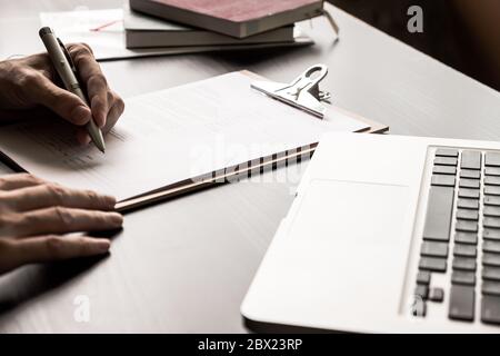 Nahaufnahme des Geschäftsmannes, der Vertrag Dokument auf dem Büroschreibtisch unterzeichnet. Stockfoto