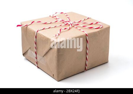 Geschenkpaket in braunem Papier auf weißem Hintergrund verpackt. Stockfoto