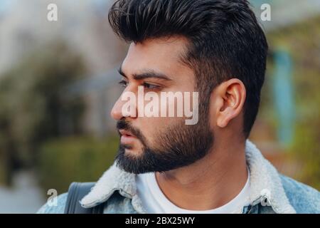 Stilvoll gekleideter indischer Bärtiger geht die Straße hinunter. Stockfoto