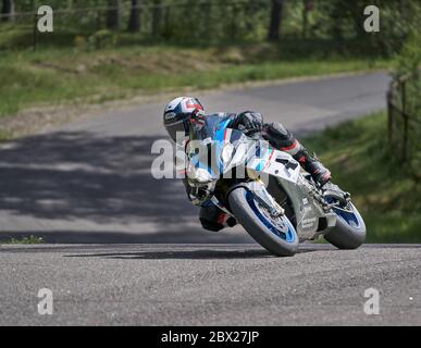 25-05-2020 Riga, Lettland. Motorradfahrer fährt auf Straße, Seitenansicht, Nahaufnahme. Stockfoto