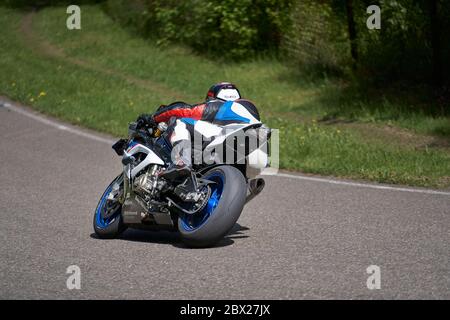 25-05-2020 Riga, Lettland. Motorradfahrer fährt auf Straße, Seitenansicht, Nahaufnahme. Stockfoto