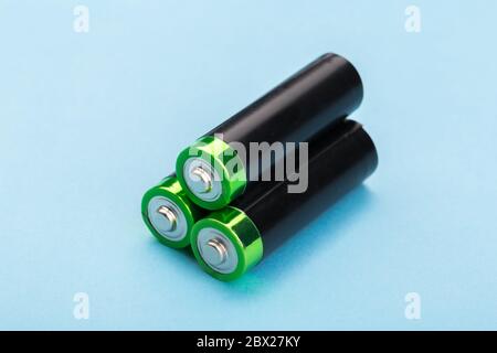 Viele neue und gebrauchte AA-Batterien auf blauem Hintergrund. Stockfoto