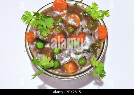 Bio-Fingerhirse-Mehl-Suppe in einer Schüssel mit Karotten und Minzblättern garniert Stockfoto