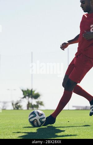 Afroamerikanischer Fußballspieler, der auf dem Rasen trainiert Stockfoto