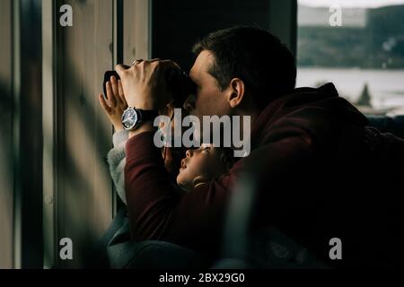 Vater und Tochter schauten mit einem Fernglas aus dem Fenster Natur Stockfoto