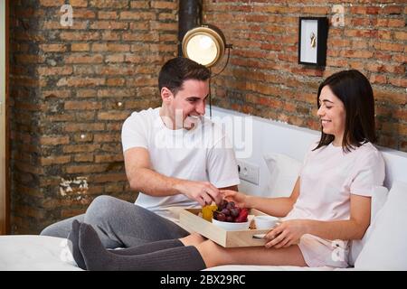 Junges Paar mit einem gesunden Frühstück und Entspannung im Bett im Haus. Stockfoto