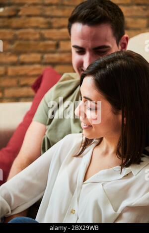 Junge intime heterosexuelle Paar entspannen auf der Couch zu Hause. Stockfoto