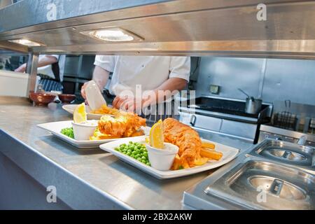 Fisch und Chips in der kommerziellen Küche in Großbritannien zubereitet Stockfoto