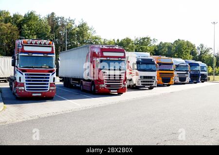 Transport. Mehrere Lastwagen standen in einer Reihe auf einem Parkplatz. Stockfoto