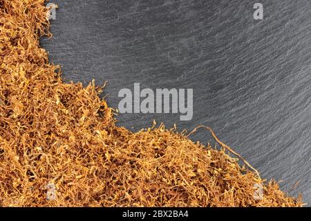 Getrocknete zerfetzte Hand rollenden rauchenden Tabak auf einem Steinschiefer Hintergrund Stockfoto