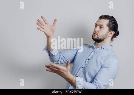 Erfolgreicher schöner Geschäftsmann mit Bart zeigt zur Seite. Stockfoto