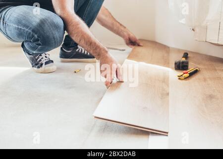 Längsschloss - die Reihenfolge der technologischen Methoden für die Verlegung und Installation von schwimmenden Bodenbelägen - Laminat - professionelle Arbeit Stockfoto