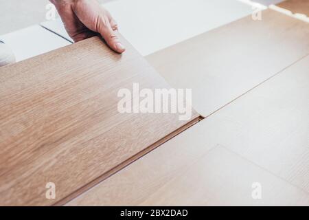 Längsschloss - die Reihenfolge der technologischen Methoden für die Verlegung und Installation von schwimmenden Bodenbelägen - Laminat - professionelle Arbeit Stockfoto