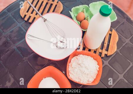 Kochen dünne Pfannkuchen - Kneten Teig - Zutaten auf dem Tisch Stockfoto