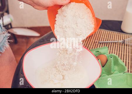 Kochen dünne Pfannkuchen - Kneten Teig - Hinzufügen von Mehl zu Teig Stockfoto