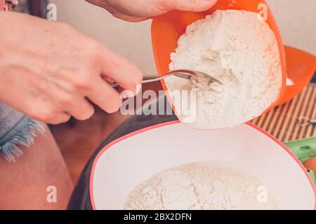 Kochen dünne Pfannkuchen - Kneten Teig - Hinzufügen von Mehl zu Teig Stockfoto