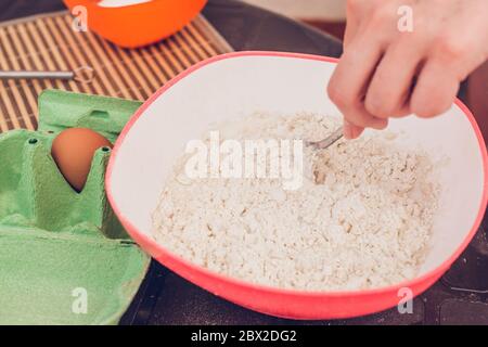 Dünne Pfannkuchen kochen - Teig kneten - Teig von Hand mischen Stockfoto