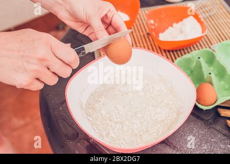 Kochen dünne Pfannkuchen - Kneten Teig - Eier in den Teig Stockfoto