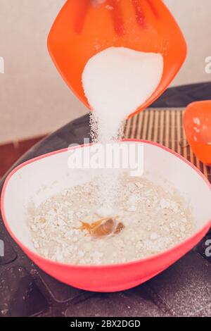 Kochen dünne Pfannkuchen - Kneten Teig - Hinzufügen von Zucker zum Teig Stockfoto