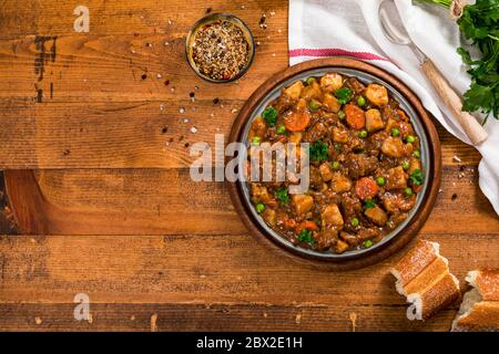 Rind Curry Eintopf mit Kartoffeln und Karotten auf Holzhintergrund Stockfoto