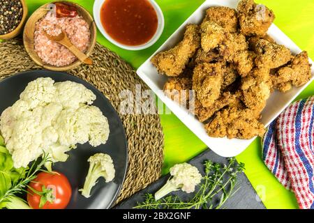 Gebratener Blumenkohl auf Küchentisch. Vegetarisches Essen. Blumenkohl mit Chilisauce. Gesundes Gemüse. Stockfoto