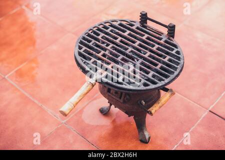 Tragbarer Hausgrill für kleine Portionen - Gusseisen Grill über Holzkohle Stockfoto