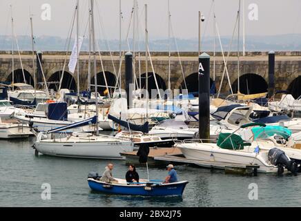 Kleines Motorboot, das mit drei Personen an Bord von Cantabria Spanien in die Marina von Santander fährt Stockfoto