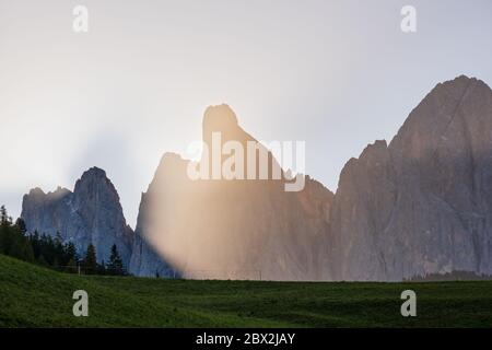 Herbst Geisler oder Geisler Dolomiten Berggruppe Felsen in contra Licht Sonnenschein Morgen trüb, Blick von Santa Magdalena berühmten Italien Dolomiten Dorf. Stockfoto