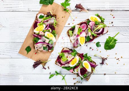 Eingelegtes mariniertes Hering und Rote Bete offenes Sandwich auf Roggenbrot. Traditionelles Dänisches Smorrebrod Stockfoto