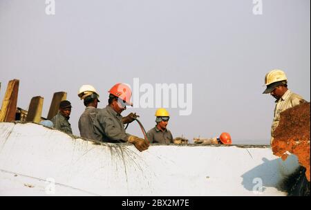 Shipbreaking Yard in Darukhana, Mumbai, Indien – INS Vikrant Abbau mit Schrott & Arbeiter im Hintergrund Stockfoto