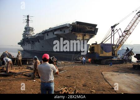 Shipbreaking Yard in Darukhana, Mumbai, Indien – INS Vikrant Abbau mit Schrott & Arbeiter im Hintergrund Stockfoto