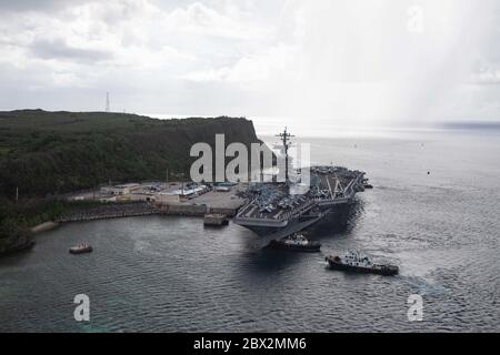 Apra Harbor, Usa. Juni 2020. Die Matrosen der US-Marine bemannen die Schienen, während der Flugzeugträger der Nimitz-Klasse USS Theodore Roosevelt von Schlepper-Booten in den Marinestützpunkt Guam 4. Juni 2020 in Apra Harbour, Guam, ins tiefe Wasser geschleppt wird. Das Schiff hat nach einer Quarantäne der COVID-infizierten Crew die Qualifikation für den Transporteur abgeschlossen und ist nun bereit, den Einsatz in der 7. Flotte fortzusetzen. Quelle: MCS Kaylianna Genier/USA Navy/Alamy Live News Stockfoto